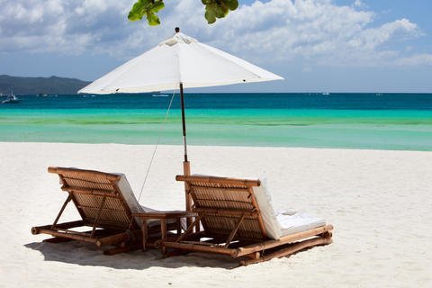 Beach chairs on white sand beach in Philippines.